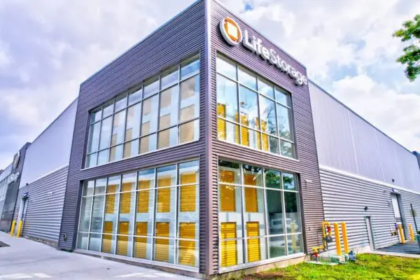 A modern storage facility with large windows and a sign reading "Life Storage" on the corner of the building.