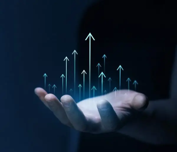 A hand is shown with digital arrows pointing upwards, symbolizing growth or progress, on a dark background.