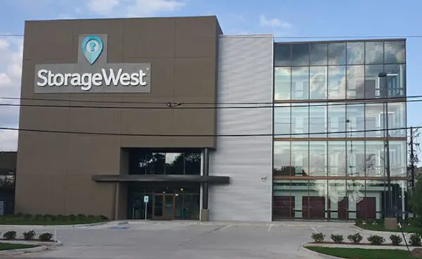 Storage West building with a modern facade, featuring large windows and the company logo on a brown wall.