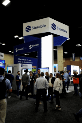 A group of people interact at the Storable booth during a convention or trade show, with banners and displays set up around the area.