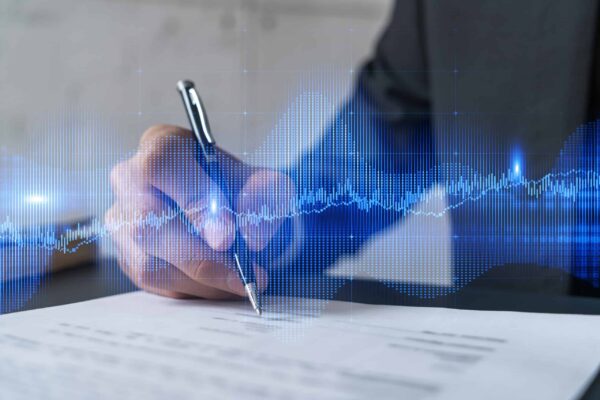 Person in a suit signing a document with a pen. A digital sound wave graphic overlays the image, creating a blend of analog and digital concepts.
