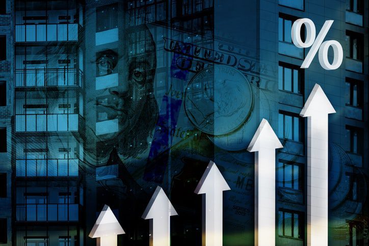 Graph with ascending white arrows, a percentage symbol, and a backdrop of buildings and money, indicating financial growth or rising interest rates.