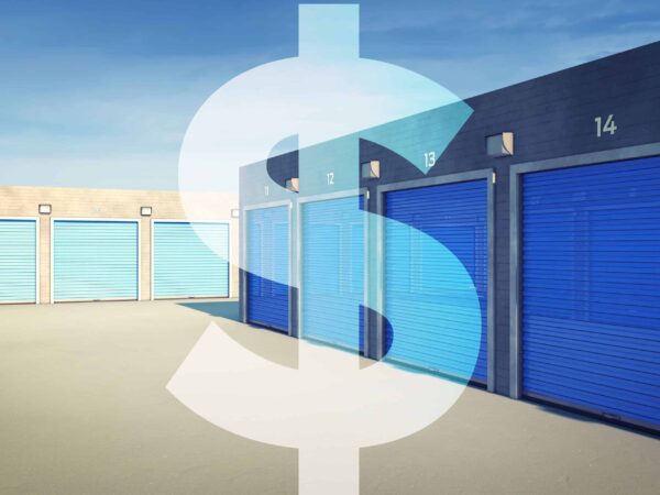 Row of blue storage unit doors with large white dollar sign overlay, against a clear sky.