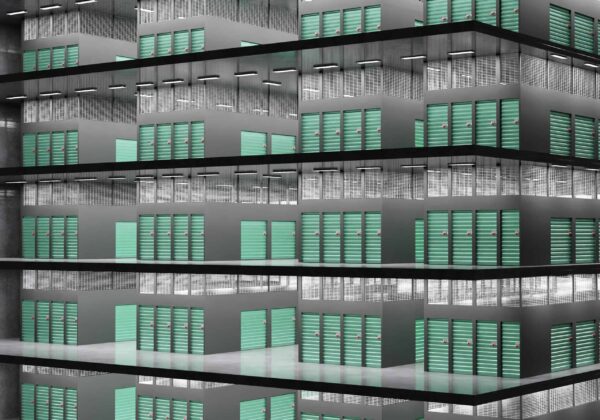 A multi-story building facade featuring numerous rows of teal-colored balcony doors, arranged in a repetitive geometric pattern.