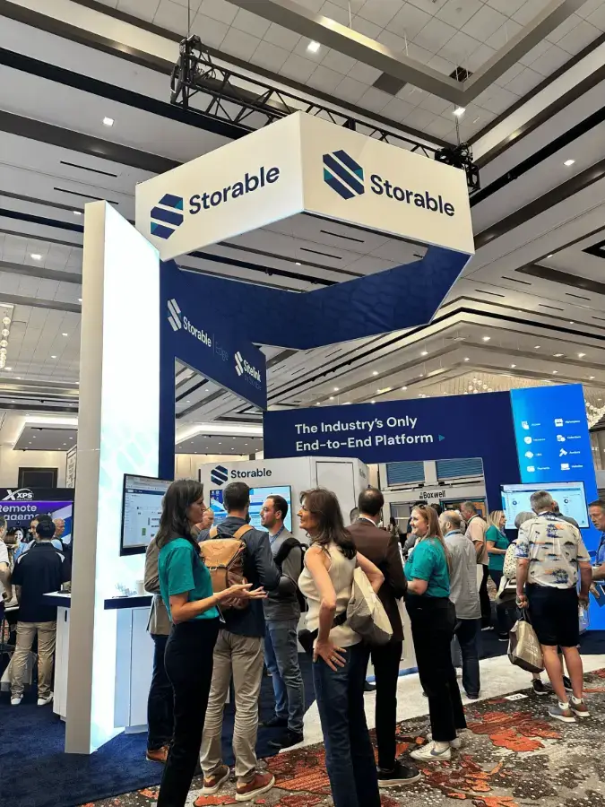 People gather and interact at the Storable booth during a trade show, with displays, signage, and technology demonstrations visible.